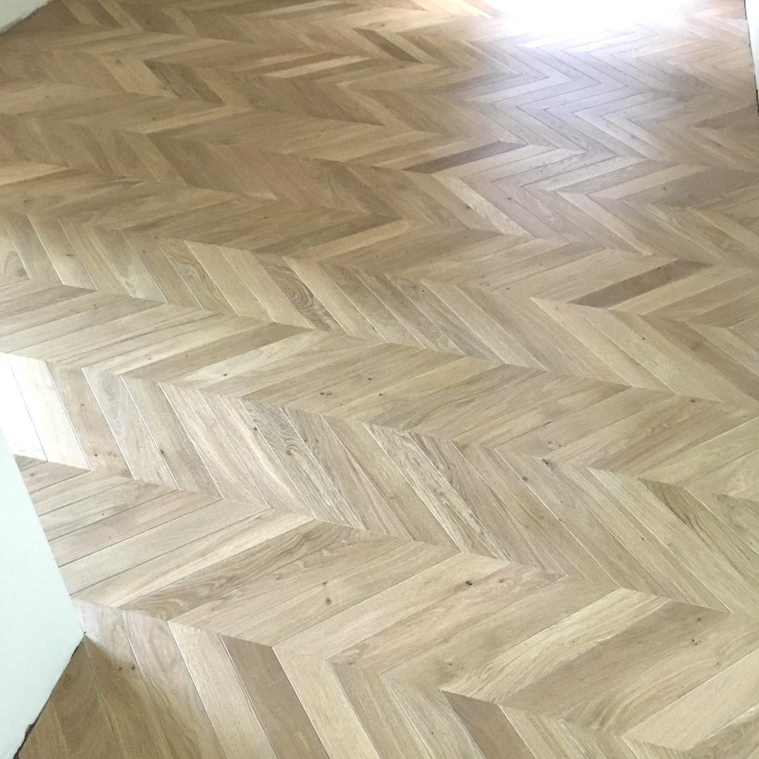 Parquet point de Hongrie en chêne clair, chevrons assemblés en V continu