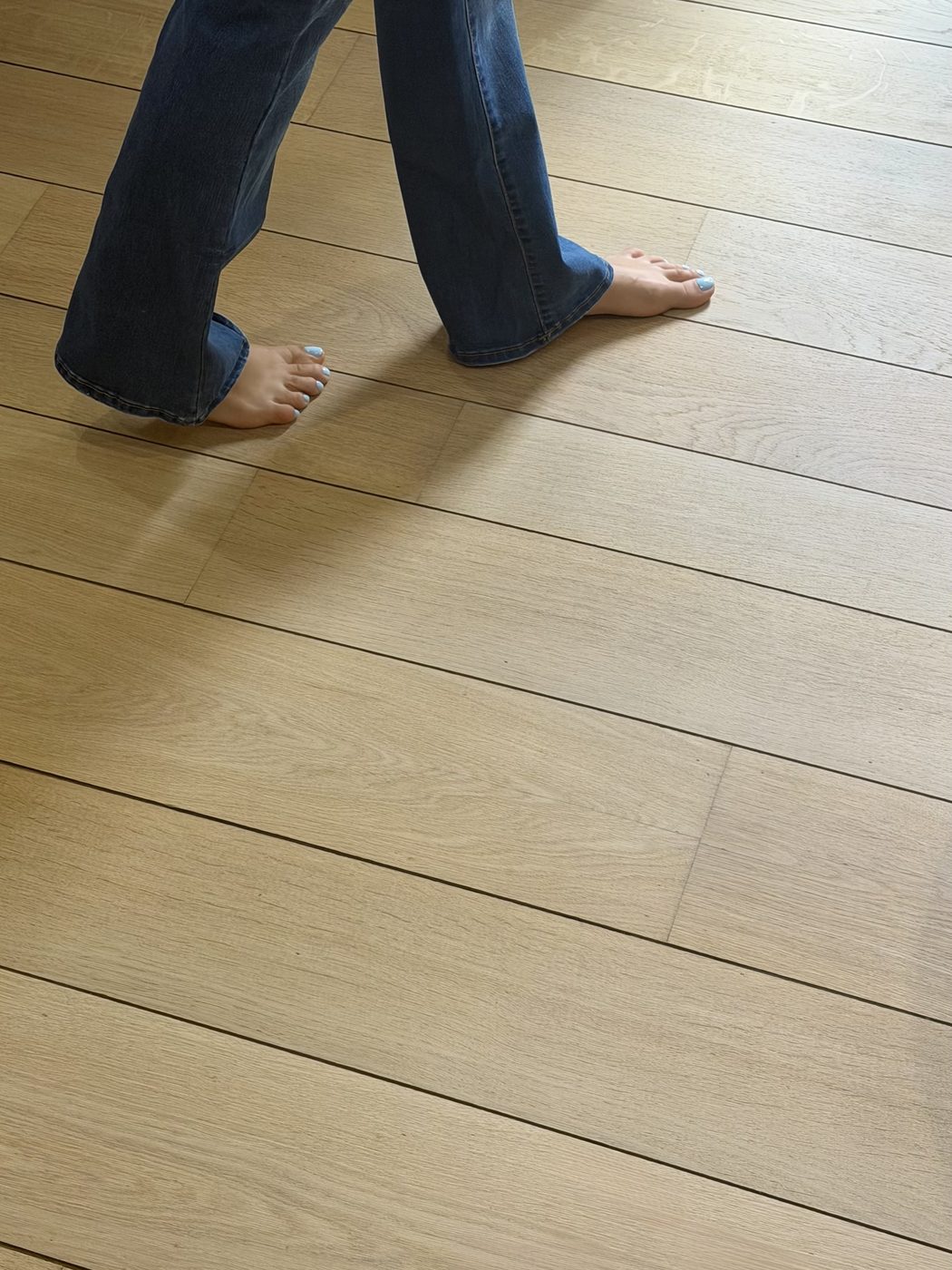 Pieds nus sur un parquet en chêne clair fraîchement posé
